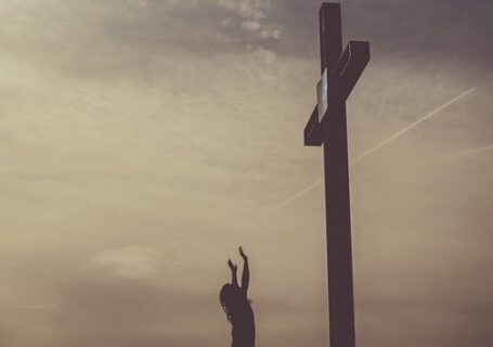 Kobieta modli się pod krzyżem