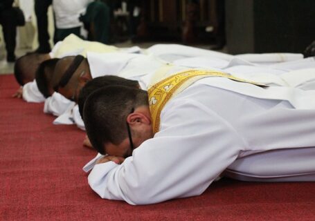 Ksiądz modlący się krzyżem